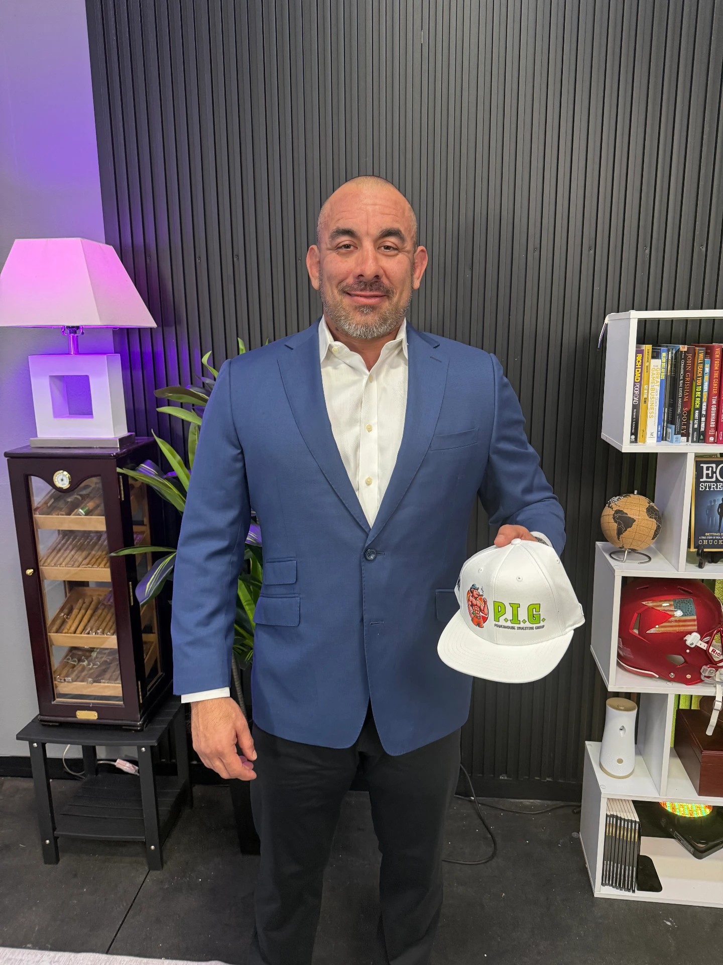 P.I.G. member holding a P.I.G. hat in the studio